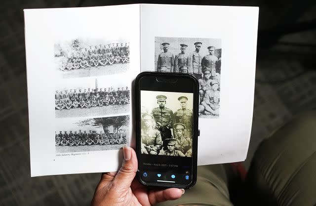 <p>Elizabeth Conley/Houston Chronicle via Getty</p> Angela Holder, whose great uncle was killed following the Houston riot of 1917, holds a photo of him taken when he was stationed at Camp Logan.