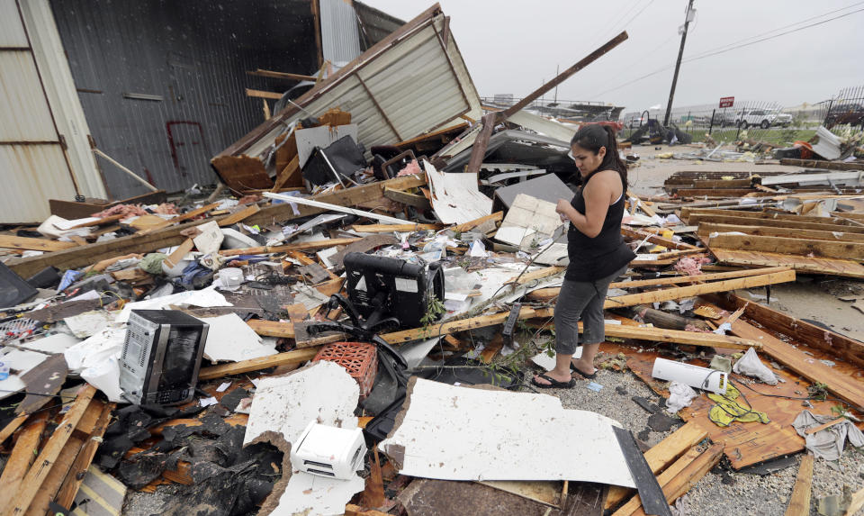 Jennifer Bryant looks over the debris from her family business destroyed by Hurricane Harvey Saturday, Aug. 26, 2017, in Katy, Texas.