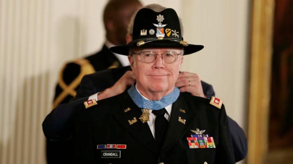 President George W. Bush places the Medal of Honor around the neck of Army pilot Lt. Col. Bruce P. Crandall, who saved dozens of soldiers in Vietnam in 1965.