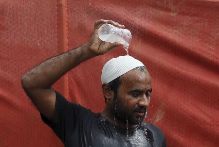 A man pours water on his head to cool off from the heat in Karachi, Pakistan, June 25, 2015. REUTERS/Akhtar Soomro