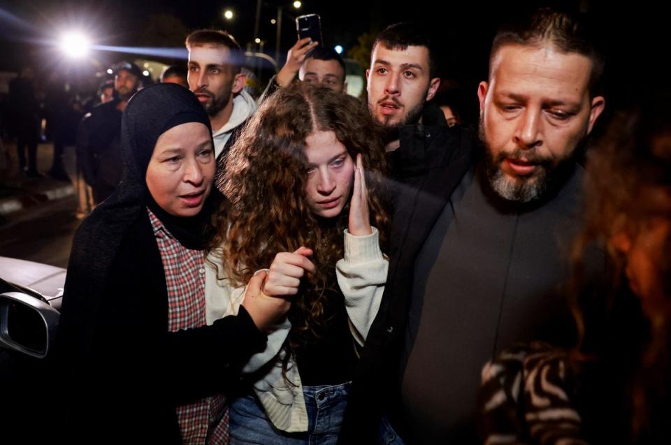 2017年掌摑1名以色列士兵巴掌，今年11月初被捕的巴勒斯坦年輕22歲活動家塔米米（前排中）獲釋，被家人緊緊圍繞，仍滿臉驚恐。   圖：達志影像／路透社