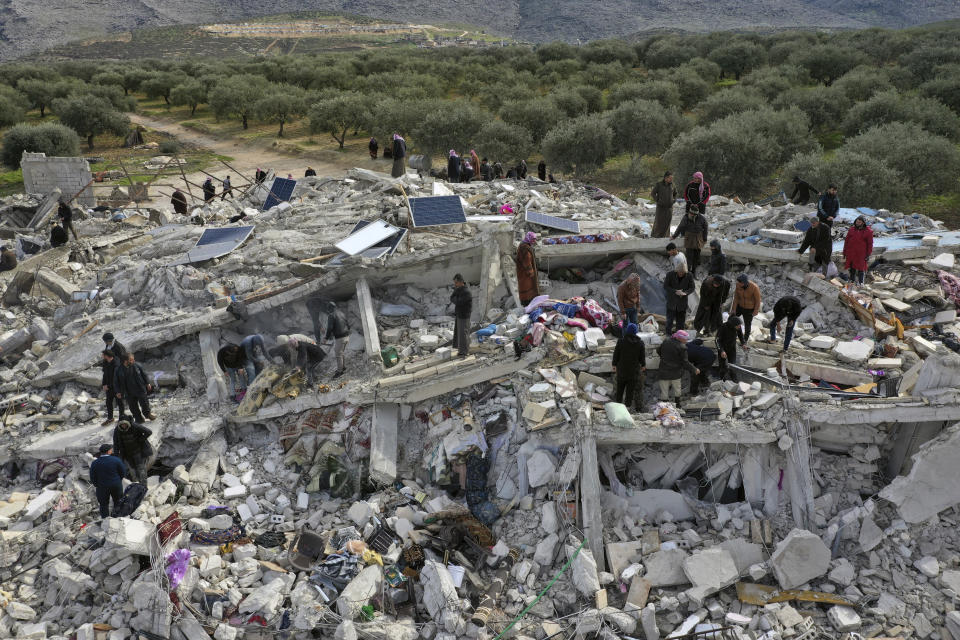 Civil defense workers and residents search through the rubble of collapsed buildings in the town of Harem near the Turkish border, Idlib province, Syria, Monday, Feb. 6, 2023. A powerful earthquake has caused significant damage in southeast Turkey and Syria and many casualties are feared. Damage was reported across several Turkish provinces, and rescue teams were being sent from around the country. (AP Photo/Ghaith Alsayed)