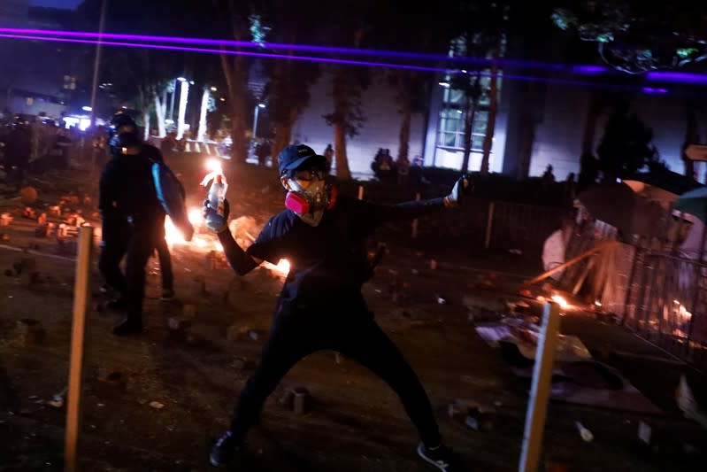 An anti-government protester throws a Molotov cocktail during clashes with the police outside the Polytechnic University in Hong Kong