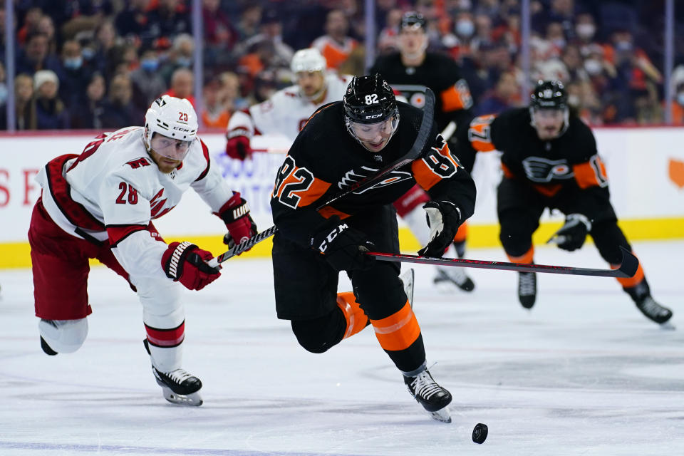 Philadelphia Flyers' Connor Bunnaman (82) skates past Carolina Hurricanes' Ian Cole (28) during the second period of an NHL hockey game, Friday, Nov. 26, 2021, in Philadelphia. (AP Photo/Matt Slocum)