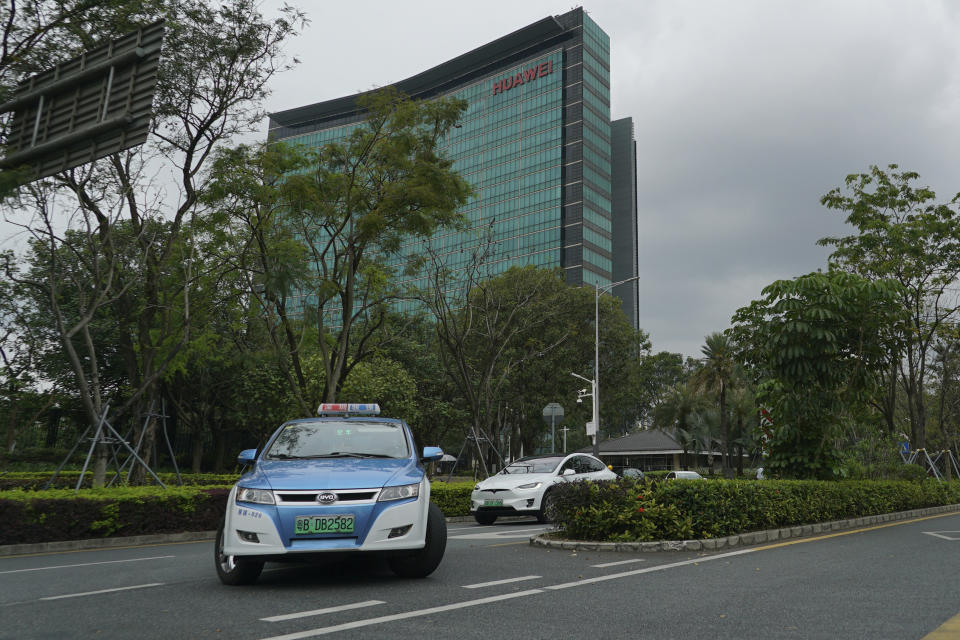 An electric taxi makes a U-turn in front of a Huawei office building in Shenzhen in south China's Guangdong province, Friday, March 29, 2019. Chinese tech giant Huawei said its 2018 sales surged above $100 billion, though sales of network equipment were flat amid U.S. warnings to other governments that its telecom technology is a security risk. (AP Photo/Dake Kang)