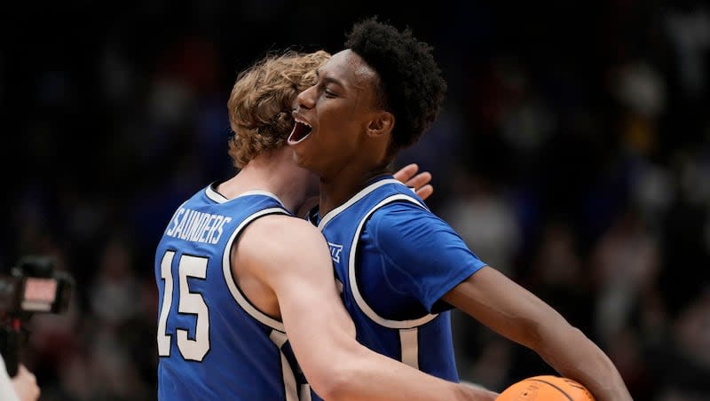 BYU guards Jaxson Robinson, right, and Richie Saunders hug after Cougars knocked off No. 7 Kansas Tuesday, Feb. 27, 2024, in Lawrence, Kan. BYU won 76-68.
