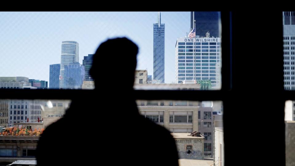 Luke, pictured in silhouette, looking at the skyline in Los Angeles