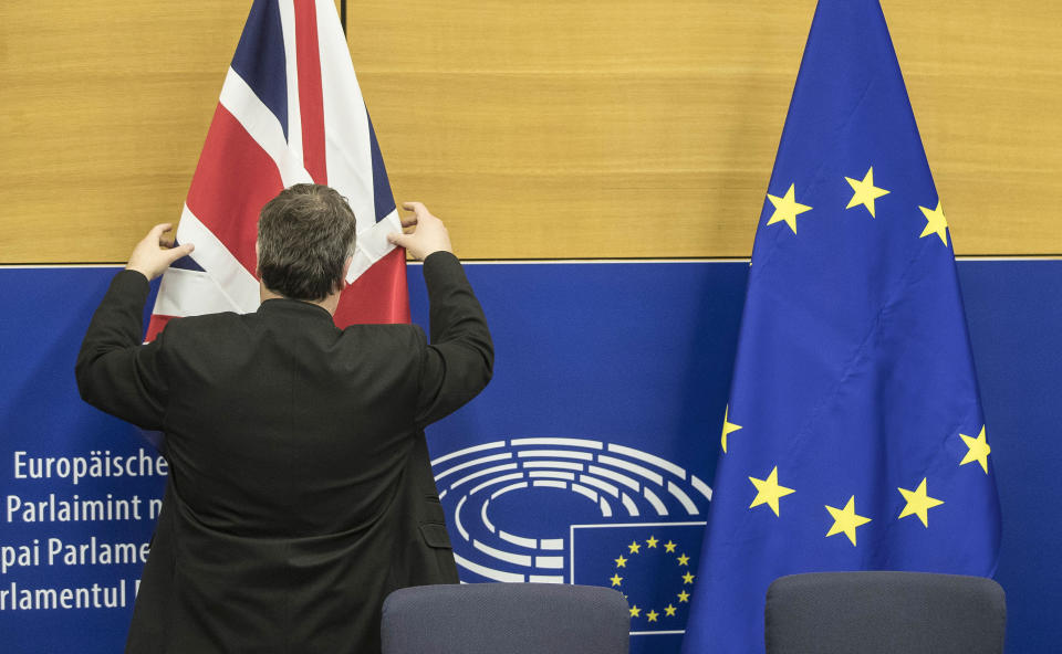 A man adjusts a British flag prior to a media conference of European Commission President Jean-Claude Juncker and Britain's Prime Minister Theresa May at the European Parliament in Strasbourg, eastern France, Monday, March 11, 2019. Prime Minister Theresa May is making a last-ditch attempt to get concessions from EU counterparts on elements of the agreement they all reached late last year. (AP Photo/Jean-Francois Badias)