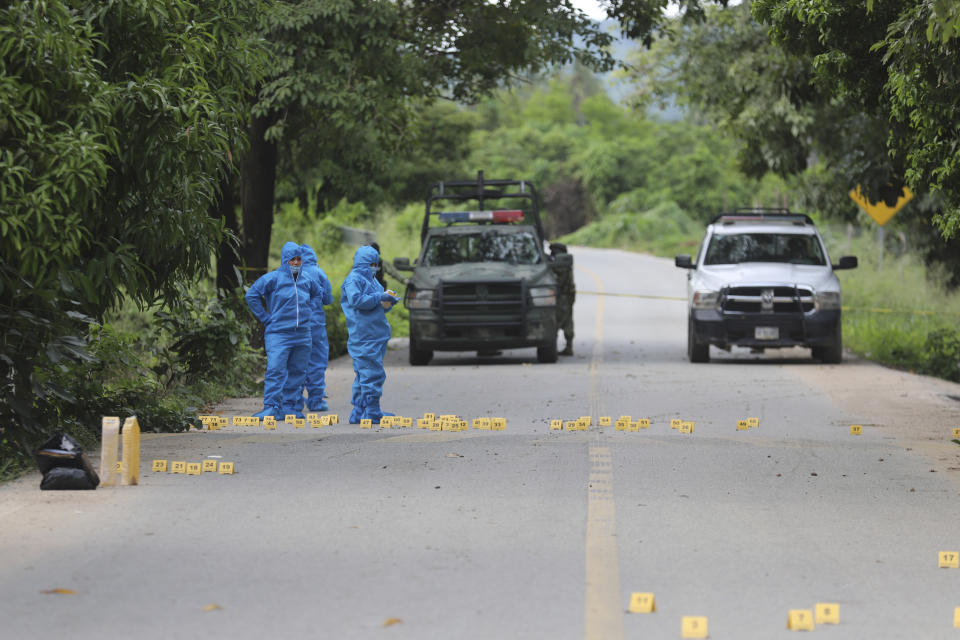 Mexican police investigators work at the scene of slain police officers in El Papayo, Coyuca de Benitez municipality, Guerrero state, Mexico, Monday, Oct. 23, 2023. Twelve police officers and their boss were gunned down on Monday, according to the Guerrero state prosecutor's office. (AP Photo/Bernardino Hernandez)