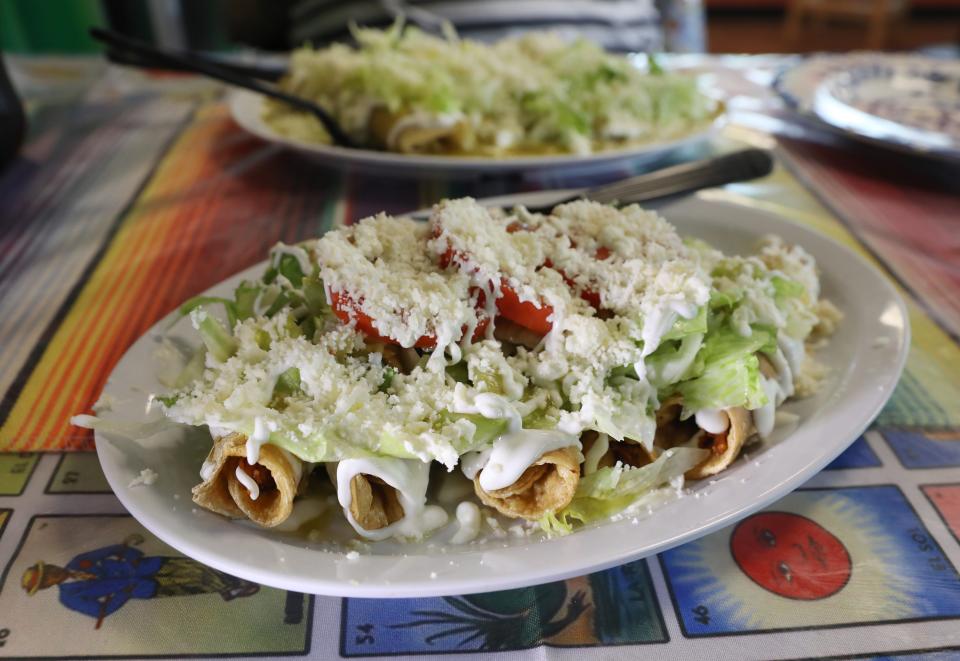 Flautas, five crunchy fried rolled tortillas filled with chicken and topped with sour cream, lettuce, tomato, salsa verde and queso, at Aguilera's Authentic Mexican Food on Monroe Ave in Rochester Tuesday, June 13, 2023. 