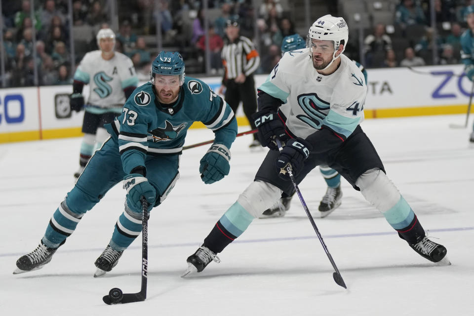 San Jose Sharks center Noah Gregor, left, reaches for the puck next to Seattle Kraken defenseman Jaycob Megna during the second period of an NHL hockey game in San Jose, Calif., Monday, Feb. 20, 2023. (AP Photo/Jeff Chiu)