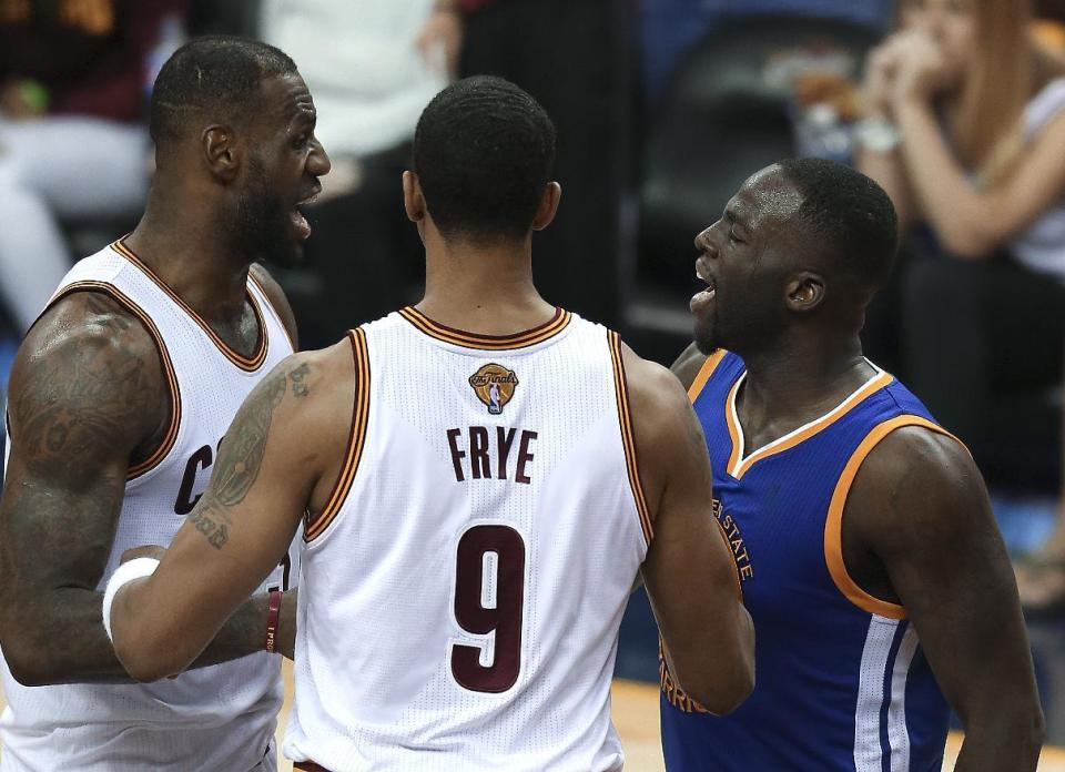 Draymond Green, derecha, de los Warriors de Golden State, discute con LeBron James, izquierda, de los Cavaliers de Cleveland, mientras son separados por Channing Frye (9) en el cuarto juego de la final de la NBA en Cleveland, el viernes 10 de junio de 2016. La NBA suspendió el domingo 12 de junio a Green para el quinto encuentro de la serie por cometer su cuarta falta fllagrante en la serie. (AP Foto/Ron Schwane)