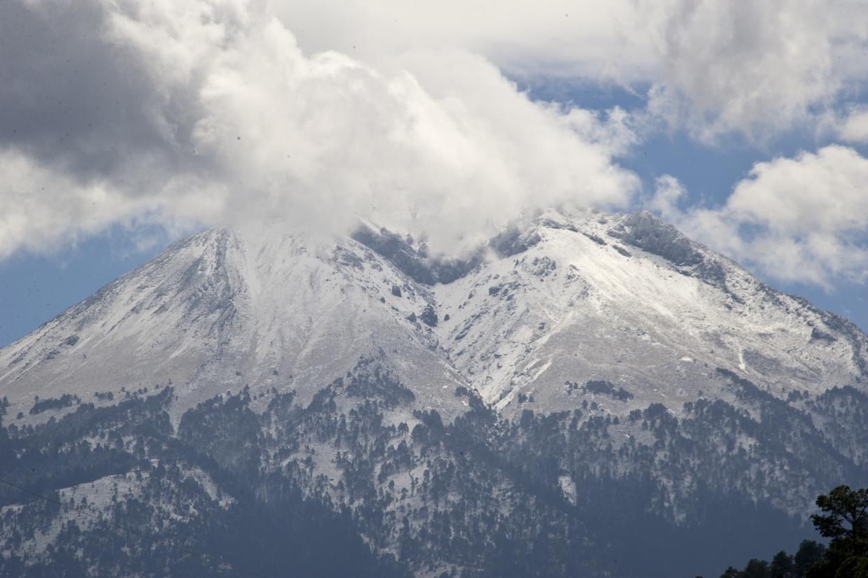 Picture taken from Tlatichuca, state of Puebla, Mexico, on March 13, 2015 of the Pico de Orizaba mountain, where four climbers died in 1959. A team of Mexican climbers searching for a frozen body on the country's highest mountain -- and North America's third -- stumbled onto a second mummified cadaver during their expedition on March 5. The 12 local civil protection mountaineers had embarked on their mission after climbers reported seeing a frozen skull 310 metres (1,000 feet) from the peak of the Pico de Orizaba. The second body was found 150 metres away, and it was also frozen and mummified, said Juan Navarro, mayor of the town of Chalchicomula de Sesma, near the mountain. AFP PHOTO/RONALDO SCHEMIDT        (Photo credit should read RONALDO SCHEMIDT/AFP/Getty Images)