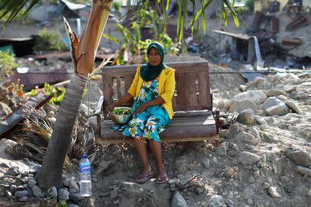 Masdiyana, 47, sits on a bench of her mother's former home which was destroyed during an earthquake in Balaroa neighbourhood, Palu, Central Sulawesi, Indonesia, October 10, 2018. Masdiyana has been trying to salvage items from her mother's home, picking vegetables and fruit from the garden. REUTERS/Jorge Silva
