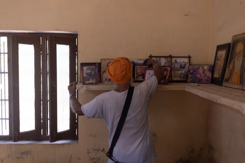 Himmat Singh Nijjar, 79, uncle of Sikh separatist leader Hardeep Singh Nijjar, arranges the family pictures inside a room at Nijjar's house at village Bharsingpura