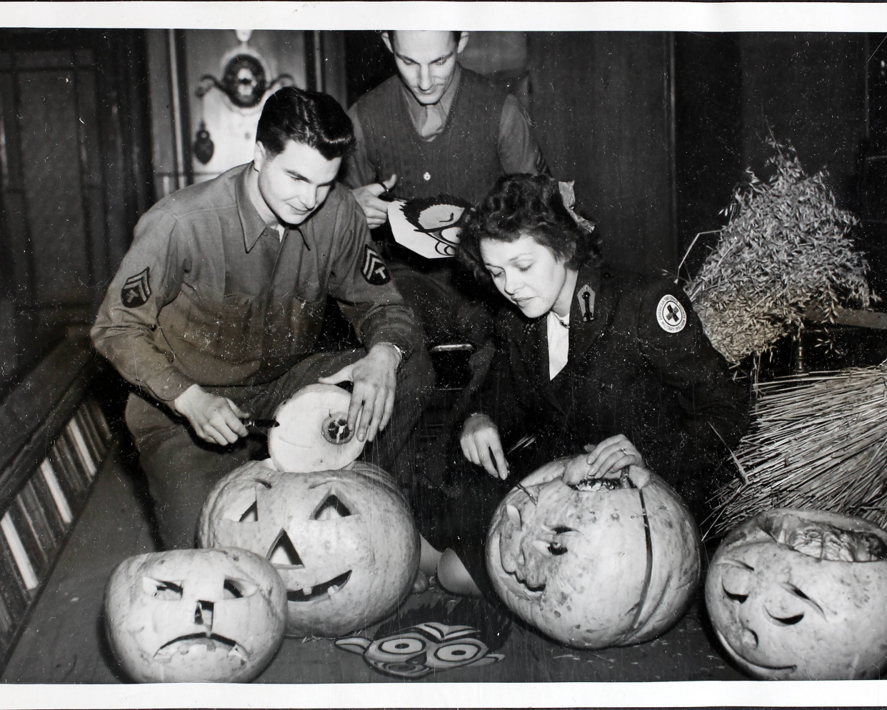 American Red Cross workers and servicemen hollowing out pumpkins in preparation for a Halloween Dance at Cheltenham Town Hall during World War II, UK