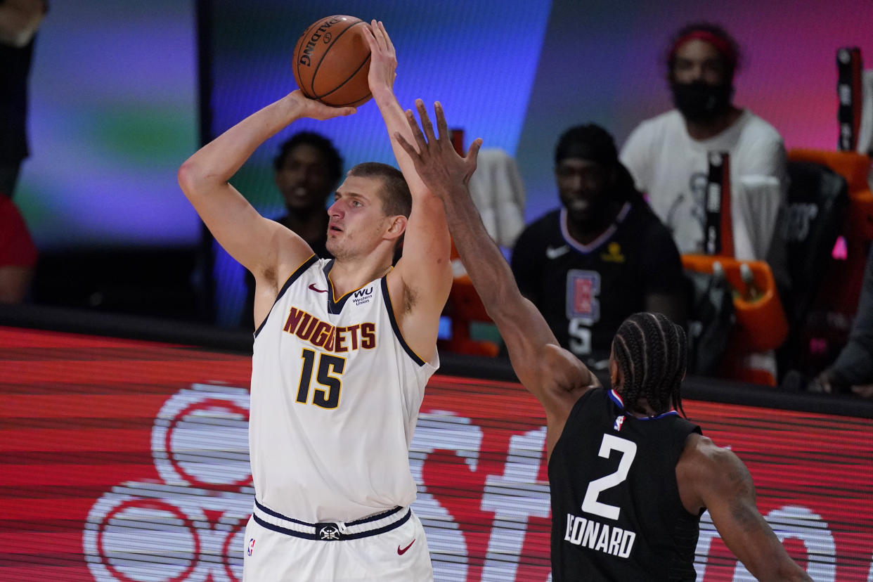 Denver Nuggets' Nikola Jokic (15) shoots in front of Los Angeles Clippers' Kawhi Leonard (2) in the second half of an NBA conference semifinal playoff basketball game Thursday, Sept 3, 2020, in Lake Buena Vista Fla. (AP Photo/Mark J. Terrill)