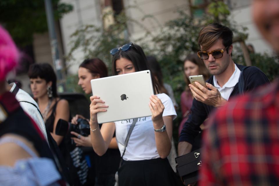 A woman holds an Apple iPad Pro.