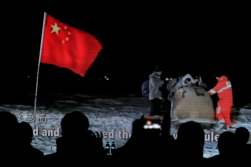 Screen shows a footage of reentry module carrying lunar samples landing on the earth during Chang'e-5 Mission, at an event in Beijing