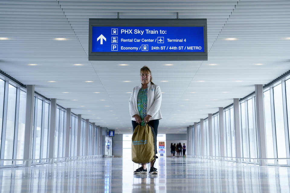 Carol Giuliani, who is a member of the Dementia-Friendly Airports Working group and works as a travel companion for seniors with dementia, stands for a portrait in Terminal 3 at Phoenix Sky Harbor International Airport after bringing a client from Minnesota Wednesday, Aug. 23, 2023, in Phoenix. “Ninety percent of the time it’s a family member that hires me,” said Giuliani, while seated at Phoenix Sky Harbor after escorting an elderly man on a flight. “The one I did today, (the wife) was like ‘thank you, thank you, thank you!’... I know how to pace it so that he gets safely and comfortably back home.” (AP Photo/Ross D. Franklin)