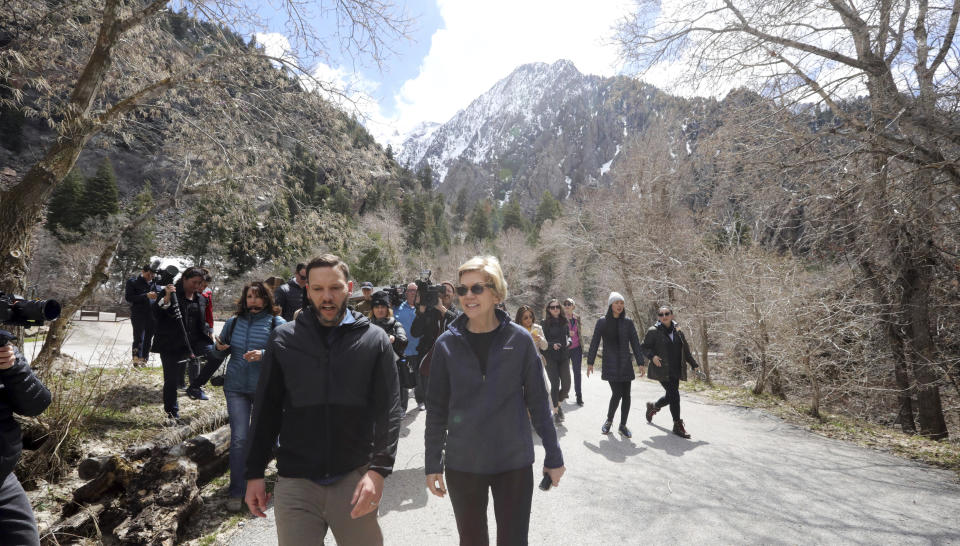 Democratic presidential candidate Sen. Elizabeth Warren, D-Mass., walks with Carl Fisher, of Save Our Canyons, during an visit to Big Cottonwood Canyon Wednesday, April 17, 2019, east of Salt Lake City. Warren is in Utah Wednesday after promising to restore broader public lands protections for two of the state's high-profile national monuments if elected president. It's a move that would not endear her to Utah's GOP establishment but could appeal to voters across the West angered by President Donald Trump's decision to shrink the monuments. (AP Photo/Rick Bowmer)