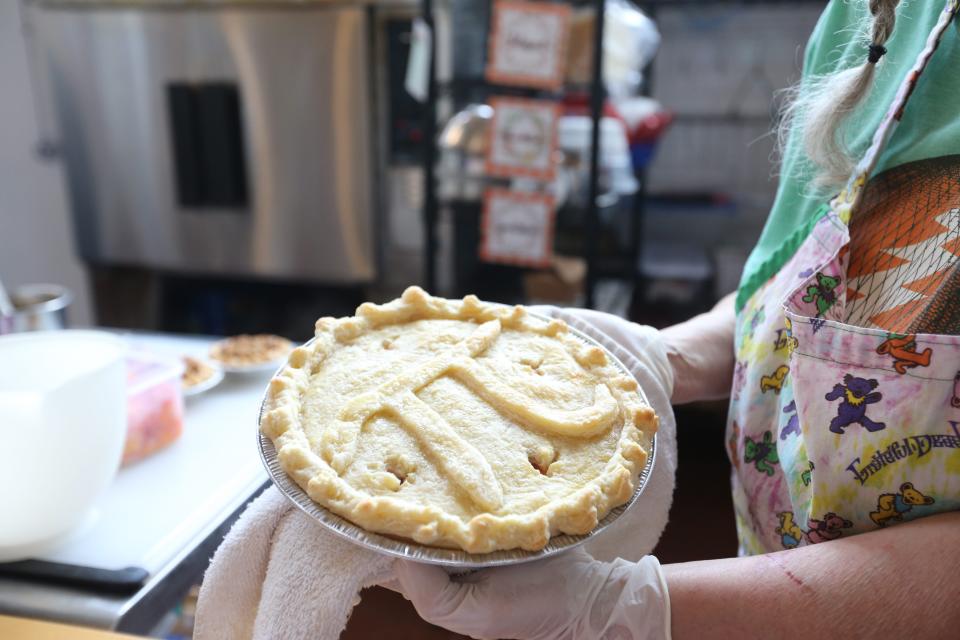 Barbara Funnell, owner of Grateful Pie Co., prepares an apple pie with a pi symbol at her bakery in South Bend, Indiana. Thursday is Pi Day, and she will celebrate her first anniversary at the site.