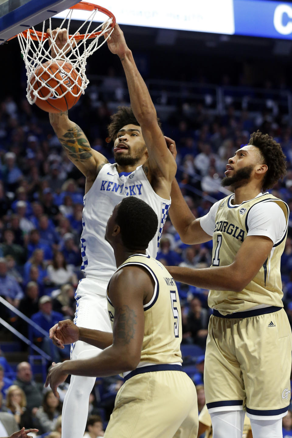 Kentucky's Nick Richards, top left, dunks near Georgia Tech's Moses Wright (5) and James Banks III during the first half of an NCAA college basketball game in Lexington, Ky., Saturday, Dec. 14, 2019. (AP Photo/James Crisp)