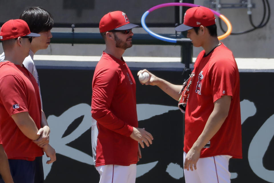 Los Angeles Angels' Shohei Ohtani, right, talks with pitching coach Doug White after throwing in the bullpen before a baseball game against the Cincinnati Reds in Anaheim, Calif., Wednesday, June 26, 2019. Ohtani threw off a mound for the first time since Tommy John surgery Oct 1, 2018. (AP Photo/Chris Carlson)