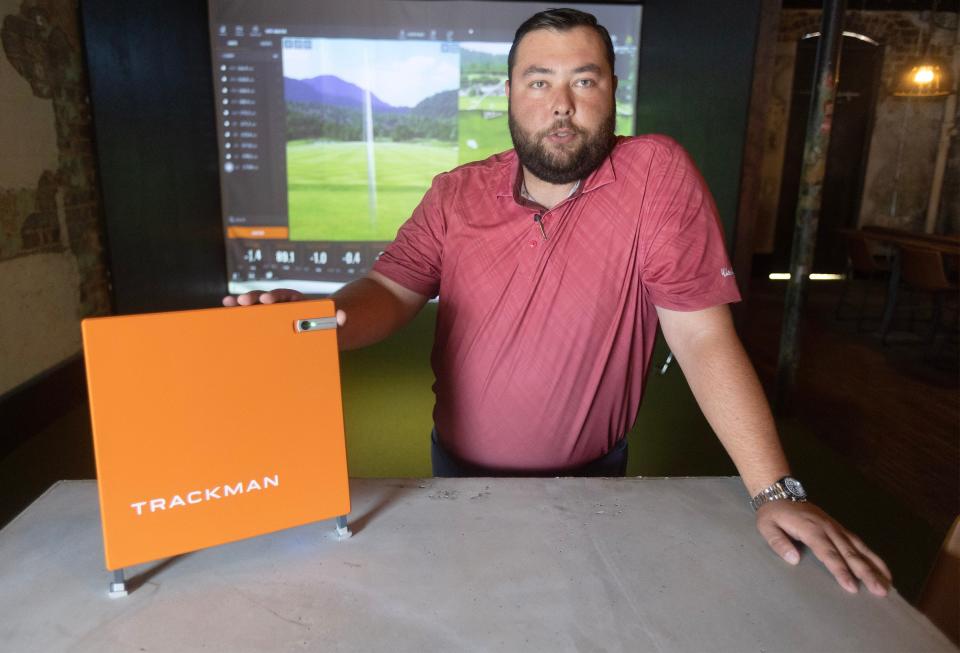 Justin Huth, golf pro at Hupp Gulf in downtown Canton, is shown with a Trackman golf simulator, which can measure swing path while tracking the ball and providing other data.