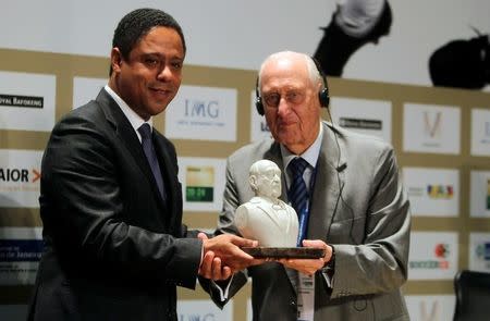 Former FIFA President Joao Havelange (R) is presented with a bust of himself by Brazil's Sports Minster Orlando Silva during the Soccerex global convention at Copacabana beach in Rio de Janeiro, November 22, 2010. REUTERS/Bruno Domingos/File photo