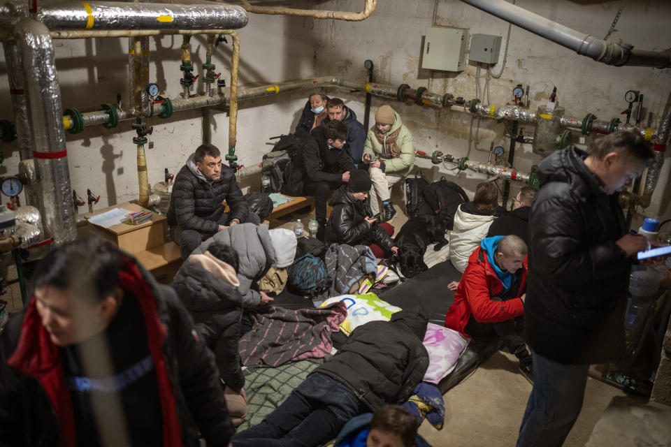 People take shelter at a building basement while the sirens sound announcing new attacks in the city of Kyiv, Ukraine, Friday, Feb. 25, 2022. (AP Photo/Emilio Morenatti)