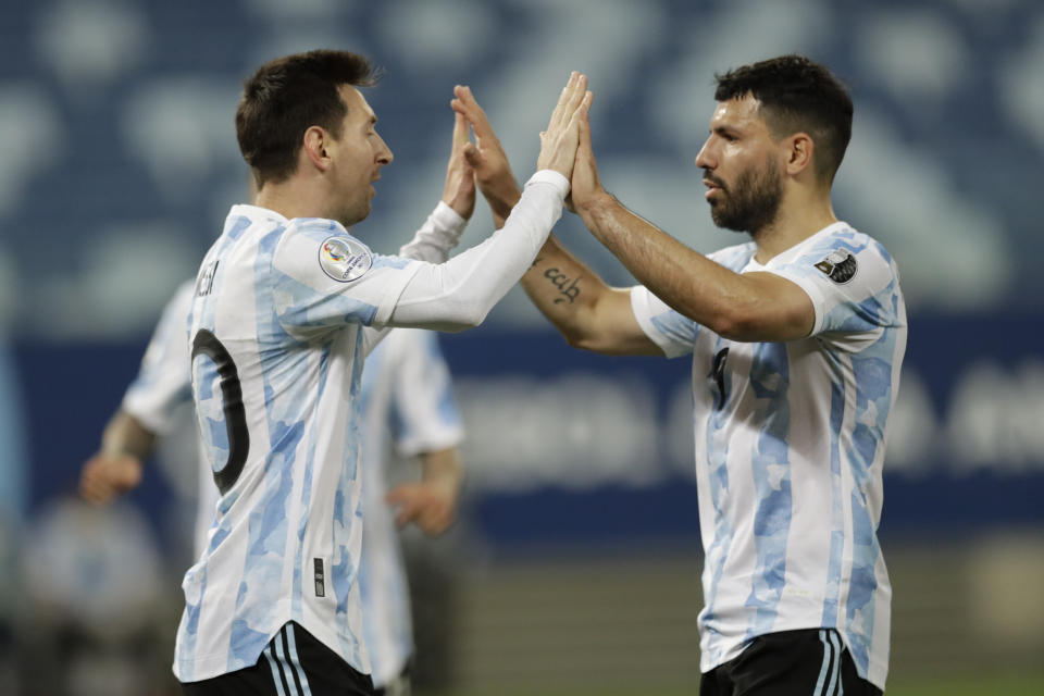 Argentina's Lionel Messi, left, celebrates scoring his side's second goal from the penalty spot with teammate Sergio Aguero during a Copa America soccer match against Bolivia at Arena Pantanal stadium in Cuiaba, Brazil, Monday, June 28, 2021. (AP Photo/Bruna Prado)