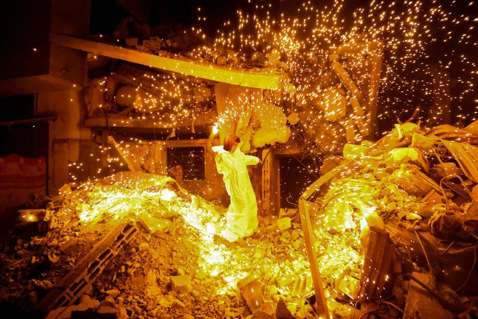 A Palestinian child plays with a sparkler in Rafah, in the southern Gaza Strip, on the eve of the Muslim holy fasting month of Ramadan on March 10, 2024, amid ongoing battles between Israel and the Palestinian militant group Hamas.