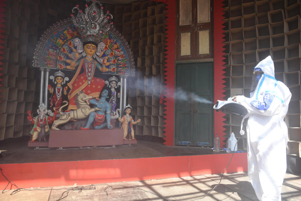 KOLKATA, INDIA OCTOBER 13: A man in PPE coveralls spray disinfectant as safety measure against coronavirus, at a Durga Puja pandal of Bhowanipore Abasar club, on October 13, 2020 in Kolkata, India. (Photo by Samir Jana/Hindustan Times via Getty Images)