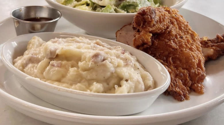 Side of mashed potatoes in ceramic dish with fried chicken
