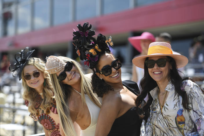 Women pose for a photograph ahead of the Preakness Stakes horse race at Pimlico Race Course, Saturday, May 15, 2021, in Baltimore. (AP Photo/Will Newton)