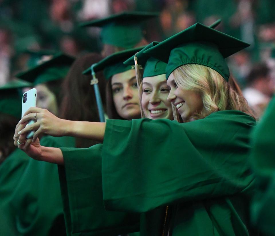 Members of the Class of 2023 take selfies Friday, May 5, 2023, following the Michigan State University 2023 Spring Commencement at the Breslin Center in East Lansing.