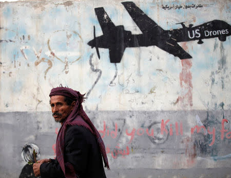 A man walks past a graffiti, denouncing strikes by U.S. drones in Yemen, painted on a wall in Sanaa, Yemen February 6, 2017. REUTERS/Khaled Abdullah