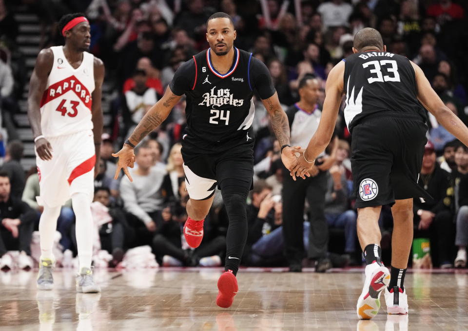 Los Angeles Clippers forward Norman Powell (24) celebrates a basket against the Toronto Raptors with Nicolas Batum during the second half of an NBA basketball game Tuesday, Dec. 27, 2022, in Toronto. (Frank Gunn/The Canadian Press via AP)