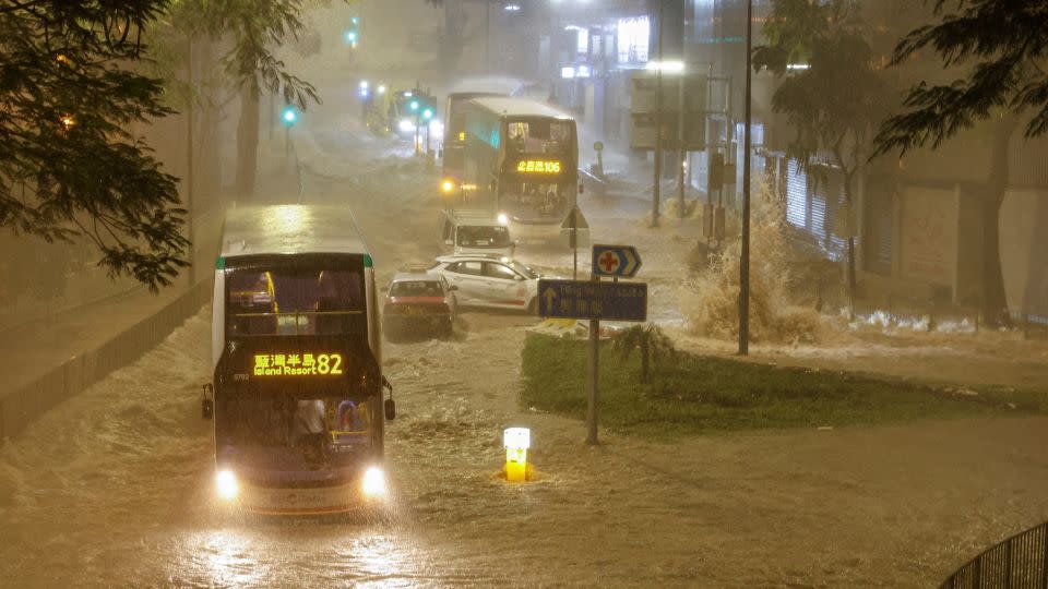 A bus drives through a flooded area in Hong Kong on September 8, 2023. - Tyrone Siu/Reuters