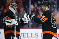 Philadelphia Flyers' Samuel Ersson, left, and Adam Ginning celebrate after the Flyers won an NHL hockey game against the Toronto Maple Leafs, Tuesday, March 19, 2024, in Philadelphia. (AP Photo/Matt Slocum)