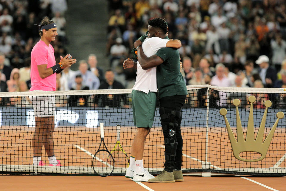 Springbok Captain Siya Kolisi, right, greets Roger Federer while Rafael Nadal looks on ahead of their exhibition tennis match held at the Cape Town Stadium in Cape Town, South Africa, Friday Feb. 7, 2020. (AP Photo/Halden Krog)