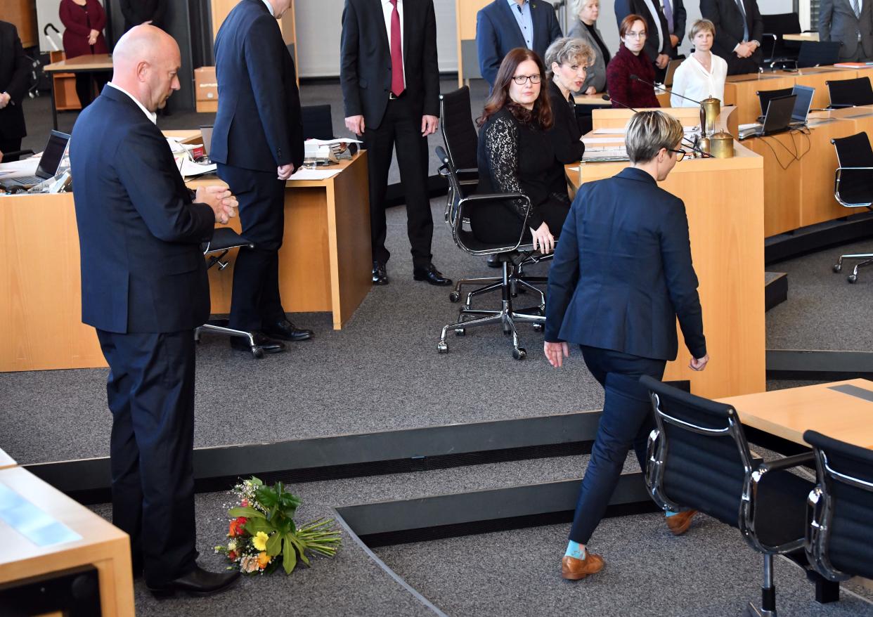 Susanne Hennig-Wellsow hat Thomas Kemmerich die Blumen vor die Füße geworfen und wendet sich ab (Bild: Martin Schutt/dpa)