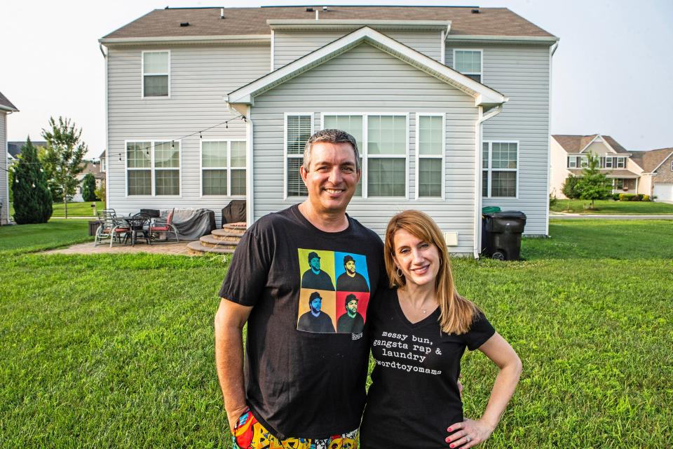 Husband and wife Chad and Marianne Hastings stand outside their home in Magnolia, Monday, July 17, 2023. The Hastings home boasts a bathroom called 'The Ice House,' which is decorated with memorabilia of rappers Vanilla Ice and Ice Cube.
