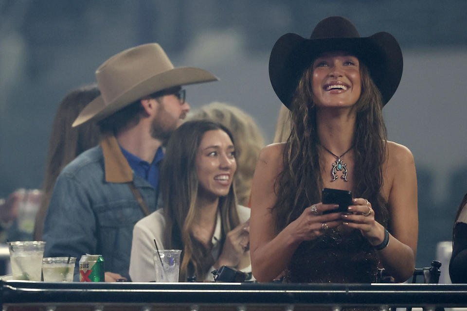 Bella Hadid appears at a rodeo to cheer on her boyfriend wearing a cowboy hat