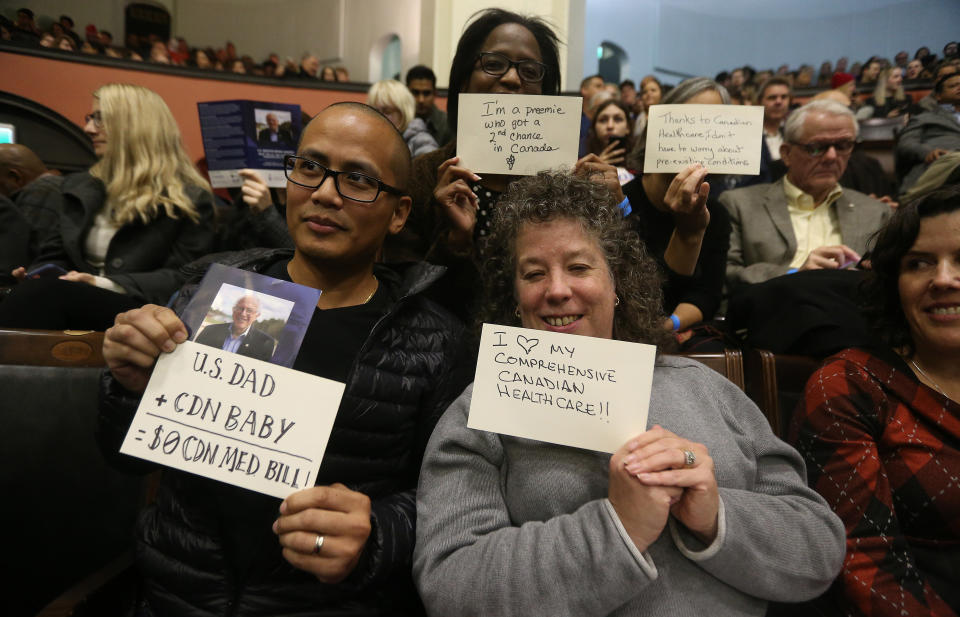 Members of the audience at Sanders' University of Toronto speech hold up cards with positive messages about Canadian health care. (Photo: Steve Russell/Toronto Star via Getty Images)