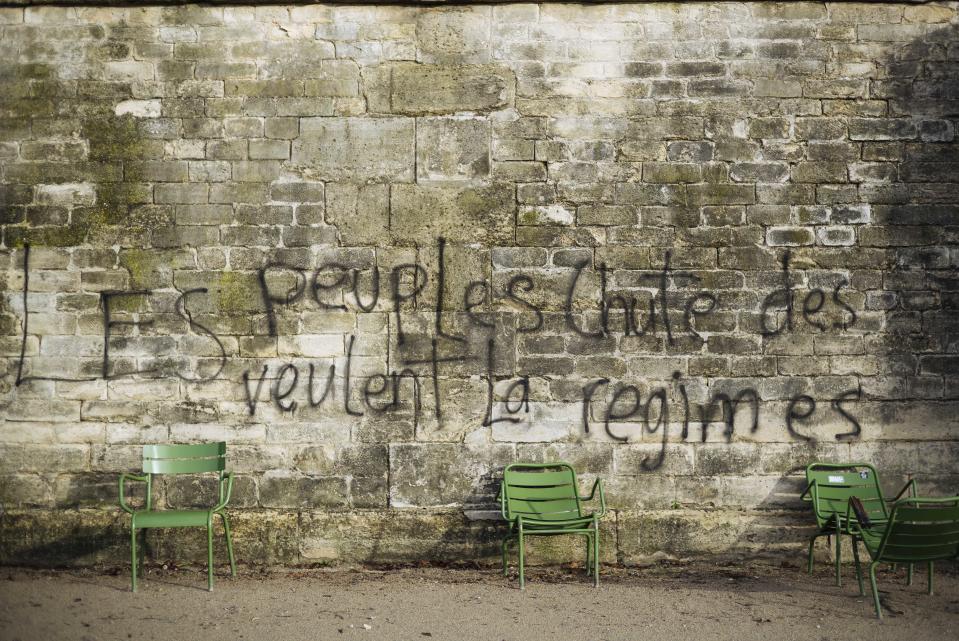 A graffiti reading "The people want the fall of systems" on a wall in the Tuileries garden in Paris, Sunday, Dec. 2, 2018. A protest against rising taxes and the high cost of living turned into a riot in the French capital Saturday, as activists caused widespread damage and tagged the Arc de Triomphe with multi-colored graffiti during clashes with police. (AP Photo/Kamil Zihnioglu)