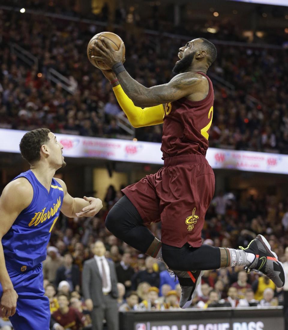 Cleveland Cavaliers' LeBron James, right, drives to the basket against Golden State Warriors' Klay Thompson in the first half of an NBA basketball game, Sunday, Dec. 25, 2016, in Cleveland. (AP Photo/Tony Dejak)