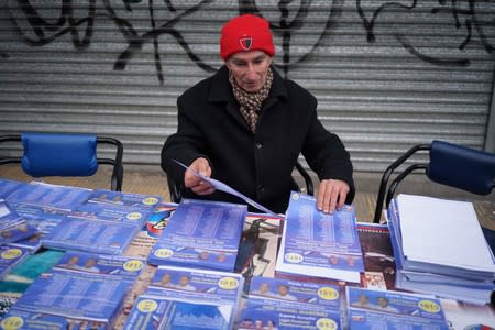 A man arranges informative materials on Daniel Martinez of the Frente Amplio party during primary elections ahead of the presidential elections later this year, in Montevideo