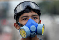 FILE - In this Oct. 19, 2020, file photo, a frontline pro-democracy student demonstrator in protective gear looks on during a rally in Bangkok, Thailand. Fed up with an archaic educational system and enraged by the military's efforts to keep control over their nation, a student-led campaign has shaken Thailand’s ruling establishment with the most significant campaign for political change in years. (AP Photo/Sakchai Lalit, File)